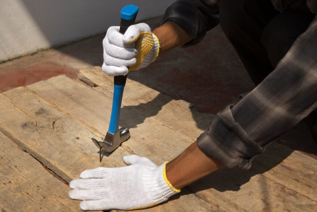 travailleur de la construction a l aide d un marteau sur le chantier
